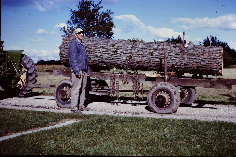 Walter Roadhouse with an oak log from his woodlot for lumber
